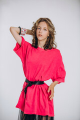 The model is a young beautiful girl in a pink dress with a transparent skirt in a studio on a white...