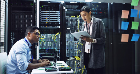 Woman, tablet and discussion with man in server room, programming and notes for IT solution at company. People, cybersecurity and talk with tech, app and information technology for system maintenance