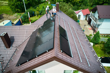 House with solar panels on rooftop for generating electricity through photovoltaic effect. Home with solar power system on roof. Concept of alternative energy, autonomy, power sustainable resources.