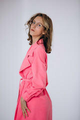 The model is a young beautiful girl in a pink dress in a studio on a white background