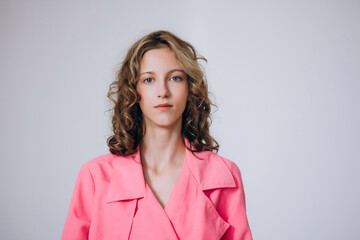 Obraz premium The model is a young beautiful girl in a pink dress in a studio on a white background