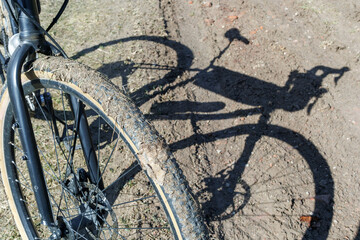 Dirty bicycle wheel on a rural dirt road close-up