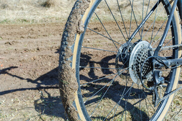 Dirty bicycle wheel on a rural dirt road close-up