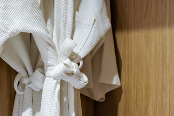 A cozy bathrobe hanging on a wooden wall.