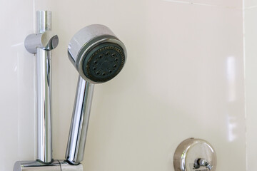 Showerhead with chrome finish mounted on a white wall.
