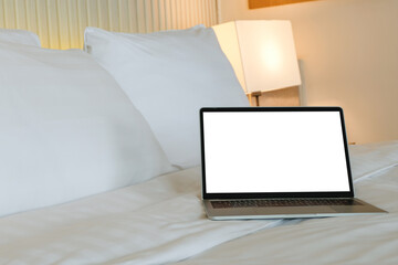 Work from anywhere concept, Cozy bed with laptop ready for work or relaxation.