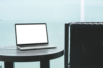 Work from anywhere concept, Modern workspace by the sea with a laptop on a table.