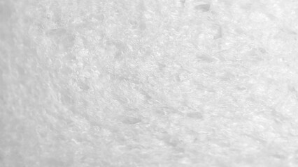 Macro shot white bread slice. Textured surface bread's interior, showing its porous, airy structure. The lighting soft and texture and  clean inviting feel