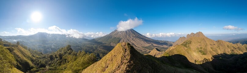 Stunning panoramic view of Mount Inerie under a clear blue sky, surrounded by green hills and dramatic clouds. Perfect for travel, nature, and adventure themes in photography and design projects.