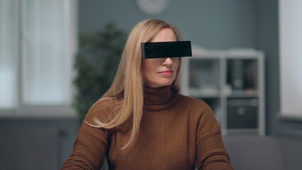 A woman is watching holographic screens, wearing black rectangle eyewear