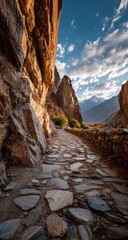 Obraz premium Mountain path through a rocky gorge. Sunlight filters through a narrow passage. Cobblestone path leading into a valley