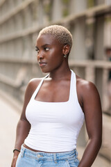 Stylish young black woman with blonde hair looking away while posing in an urban setting