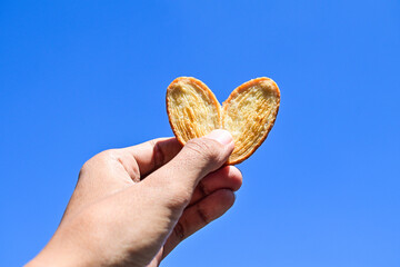 Mini pie holding by hand with Clear blue sky on the background. Isolated. Men, man, male, asian....