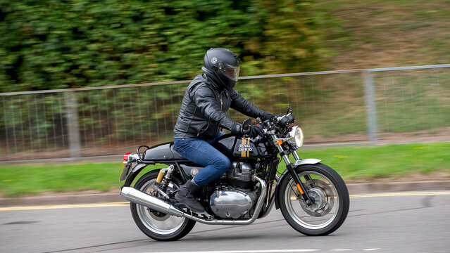Milton Keynes,Bucks,UK - Aug 3rd 2025:  Man riding a Royal Enfield classic  motorcycle travelling on a British road