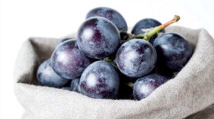 Fototapeta premium A bunch of ripe dark purple grapes nestled in a textured fabric bag fruit