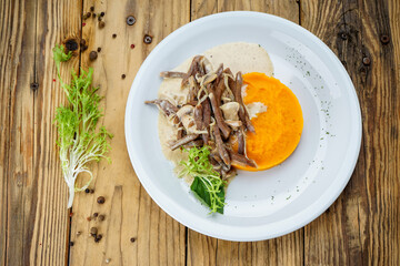 pea puree with meat and herbs in a white plate