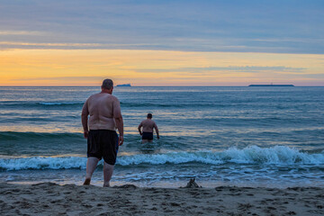 Chubby guys swimming at sunset in the Baltic Sea