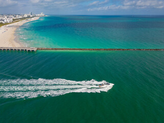 Luxury yacht cruising near Miami skyline. Aerial view of boats on turquoise waters in Miami. Yacht...