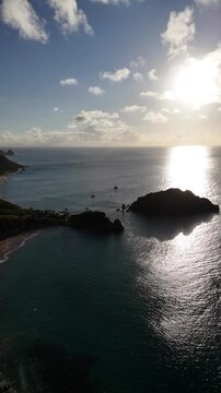 O sol se p&otilde;e em Fernando de Noronha, iluminando o mar e criando uma paisagem tropical inesquec&iacute;vel