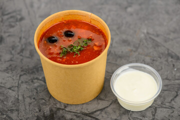 Kharcho soup with olives in a disposable container