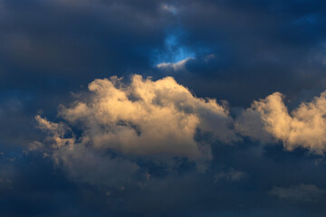 Large bright fluffy clouds against a dark mood-filled layered dramatic sky.