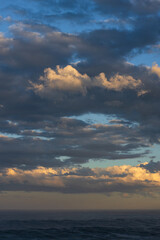 Textured moody clouds fill the sky above the ocean.