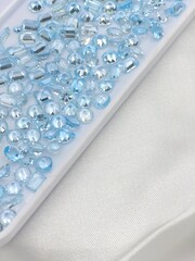 Blue gems on white paper in many shape. Blue topaz loose gems for selling