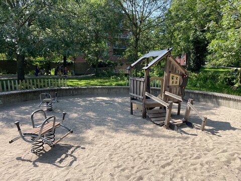 Sunny Outdoor Playground with Wooden Playhouse and Spring Riders in Sandpit Odense, Denmark