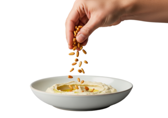 Light-skinned adult hand sprinkles toasted pine nuts over creamy baba ghanoush in a ceramic bowl, on transparent background, studio shot, culinary precision and artisanal care