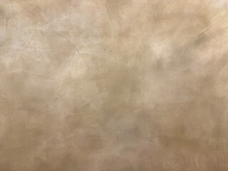 Decorative metallic gold paint on a surface. Random limestone golden washed paint with grunge, and dirt pattern. Seamless background texture.