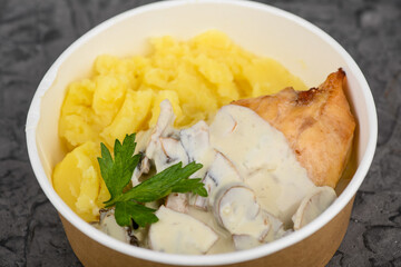 mashed potatoes with chicken fillet in mushroom sauce in a disposable dish