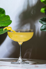 Yellow cocktail drink with whiskey, liqueur and lemon juice. Marble table in elegant bar with...