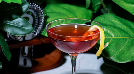 Strong alcoholic cocktail drink with gin, aperitif, bitters, liqueur and lemon twist with bar tools