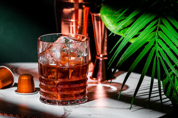 Summer Cold Caramel Coffee alcoholic cocktail drink with vodka, espresso and ice. Green background,...