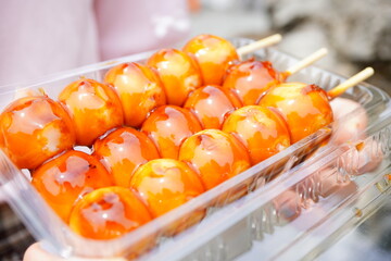 A close-up view of glossy mitarashi dango skewers coated in sweet soy glaze, showcasing the rich...