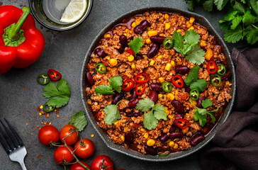 Chili con carne with beef, beans, paprika, corn, cilantro, jalapeno in tomato sauce, in frying pan,...