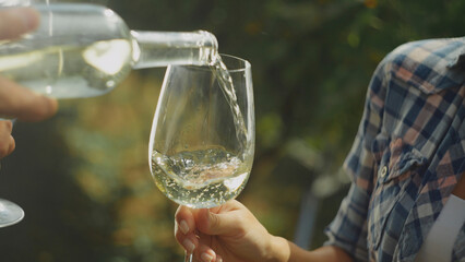 Sommelier pouring white wine into glass during wine tasting event