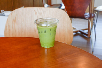 Iced matcha latte in glass on wooden table, authentic Japanese matcha latte made from Uji...