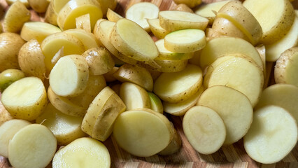 Golden potato slices glisten on a rustic wooden board, embodying harvest food rituals and earthy autumnal festivals