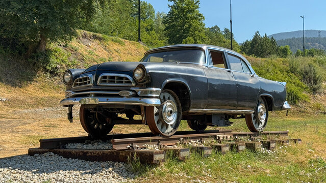 Fototapeta A vintage car on weathered rails evokes forgotten journeys, steampunk nostalgia, and National Road Trip Day adventures