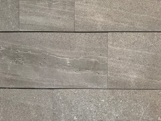 Close up of natural grey stone granite with random black veins and 3D texture. Giant grey and black granite slab, natural stone pattern suitable for wall clads. Seamless background texture