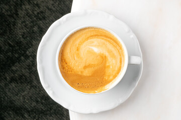Creamy cappuccino swirl resembling golden cosmic whorls, celebrating National Coffee Day and Hygge...