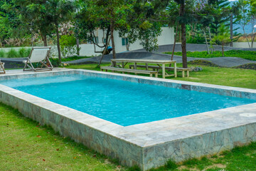 Empty swimming pool with sunbed and white umbrella in resort hotel for vacation leisure and white sand,resort neary sea and beach in summer.