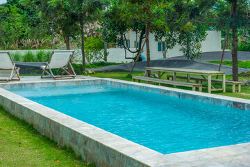 Empty swimming pool with sunbed and white umbrella in resort hotel for vacation leisure and white sand,resort neary sea and beach in summer.
