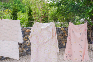 Different clothes drying on laundry line against garden background,clothes hanging laundry on...