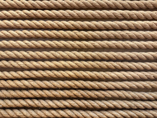 Close up of brown rope in horizontal linear direction. This synthetic breaded rope is commonly used for industrial purposes. Seamless background texture