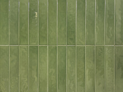 Vertical green subway tiles with white grouts. Seamless tiles background texture.