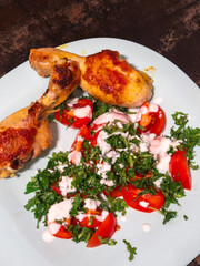 Enjoying roasted chicken legs with fresh tomato and arugula salad with yogurt dressing