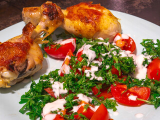 Enjoying roasted chicken legs with fresh tomato and arugula salad