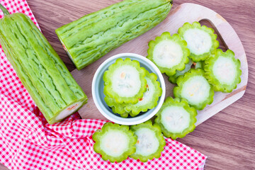 Fresh bitter gourd in white bowl on wooden table background